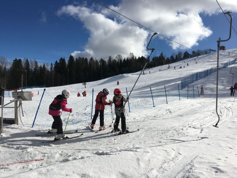 Children going up on a ski lift at a downhill skiing center in Finland.